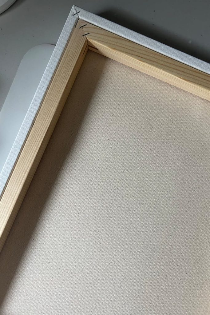 Detailed view of blank stretched canvas on a wooden frame, ideal for artists.